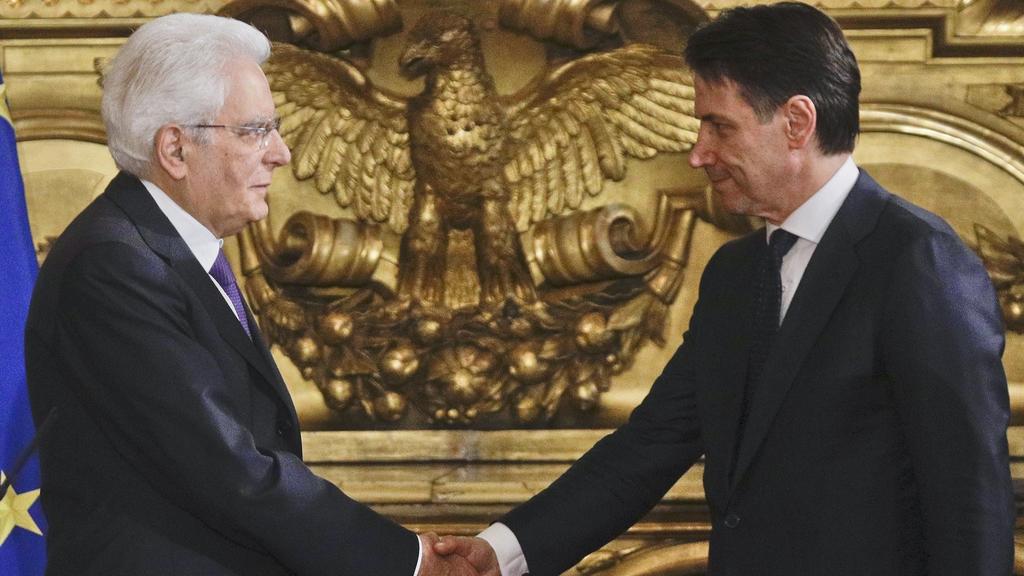 01.06.2018, Italien, Rom: Sergio Mattarella (l), Präsident von Italien, gibt Guiseppe Conte, dem neuen Ministerpräsident von Italien, während der Vereidigung der neuen Regierung von Italien im Quirinalspalast des Präsidenten die Hand.) Foto: Gregorio