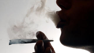 FILE PHOTO: An unidentified man smokes a cannabis cigarette at a house in London, Britain January 24, 2004.  REUTERS/David Bebber/File Photo