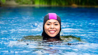 Mädchen schwimmt im Burkini