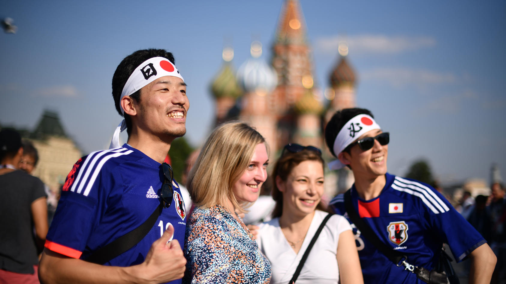 MOSCOW, RUSSIA - JUNE 18: Fans of Japan pose with russian women at Moscow Red Square on June 18, 2018 in Moscow, Russia. (Photo by Hector Vivas/Getty Images )