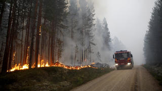 ARCHIV - 15.07.2018, Schweden, Karbole: Ein Feuerwehrwagen kommt zu einem Waldbrand in der Nähe von Ljusdal. In Schweden wüten weiter heftige Waldbrände. Die Zahl der Feuer stieg am Freitag auf mehr als 50. Gegen die größten kämen die Rettungskräfte nicht mehr an, sagte der Chef des Zivilschutzes. Foto: Mats Andersson/TT NEWSAGENCY/AP/dpa +++ dpa-Bildfunk +++