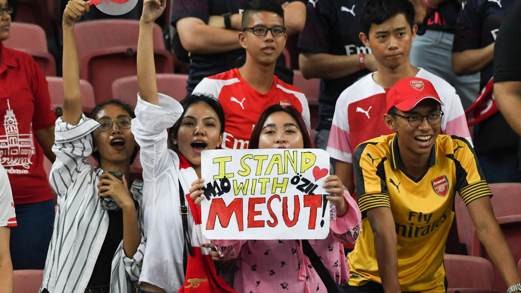 26.07.2018, Singapur: Fußball: International Champions Cup, Atletico Madrid - FC Arsenal im Singapur Nationalstadion. Ein Arsenal Fan zeigt ein Plakat mit der Aufschrift «I stand with Mesut». Foto: Stefanus Ian/dpa +++ dpa-Bildfunk +++