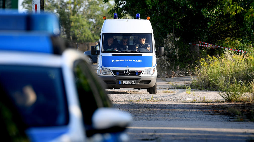 02.08.2018, Brandenburg, Ahrensfelde: Fahrzeuge der Kriminalpolizei verlassen den Einsatzort. Nach dem Fund einer männlichen Leiche am nordöstlichen Berliner Stadtrand hat eine Mordkommission die Ermittlungen übernommen. Foto: Britta Pedersen/dpa-Zen