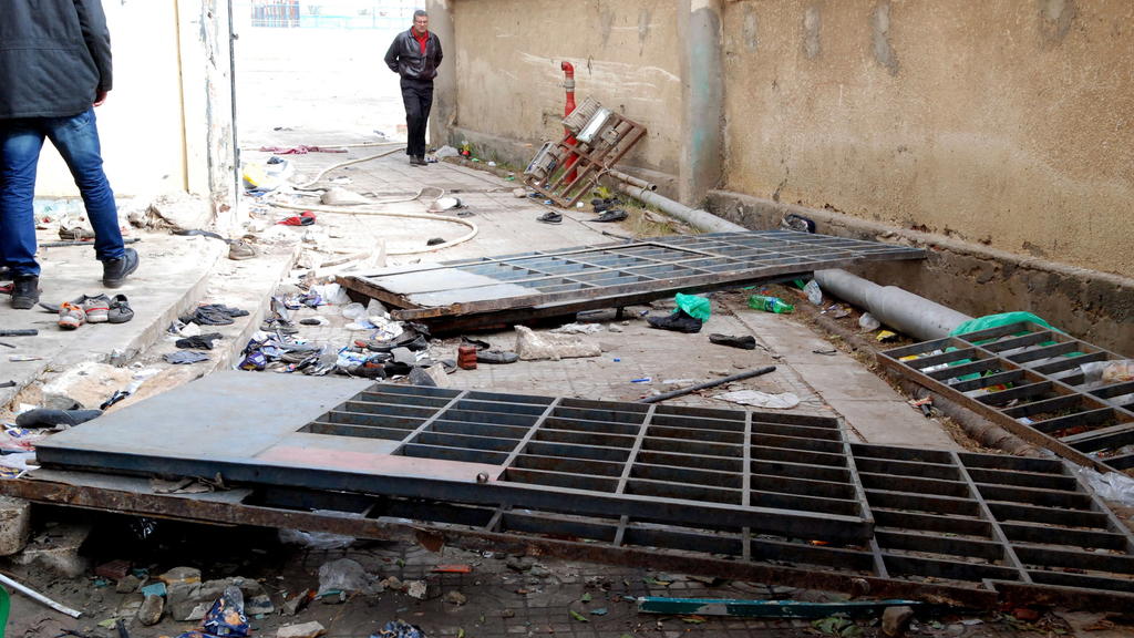 ARCHIV - 01.02.2012, Ägypten, Port Said: Schuhe und umgestürzte Tore liegen am Eingang des Fußballstadions am Tag nach den Krawallen, bei denen Fans des Heiamt-Vereins Al-Masri brutal gegen Anhänger des Kairoer Clubs Al-Ahli vorgingen. 74 Menschen ka