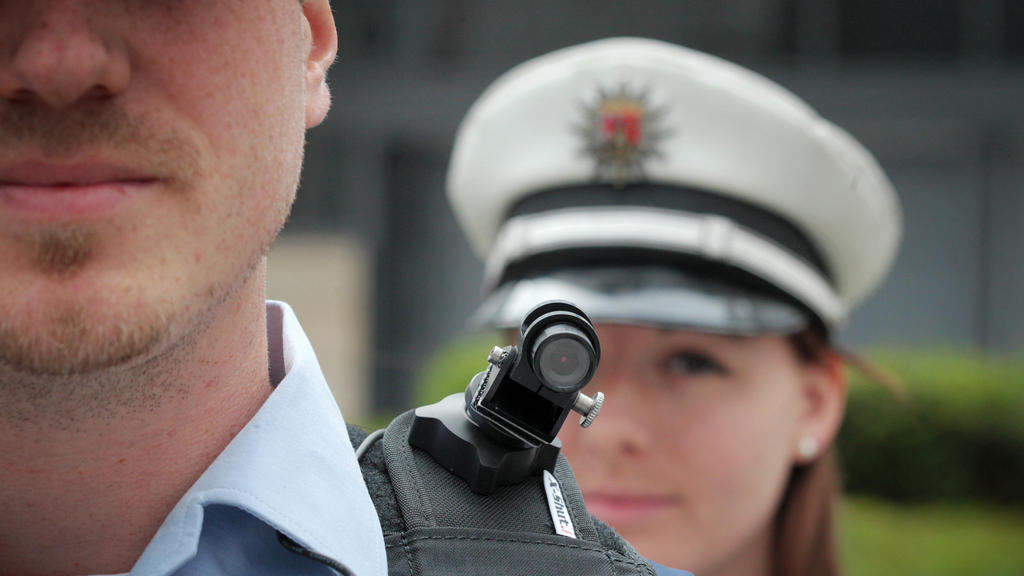 ARCHIV - 08.06.2015, Rheinland-Pfalz, Mainz: Ein Polizist trägt bei einem Pressetermin im Innenministerium eine mobile Miniatur-Videokamera auf seiner Schulter.   (zu dpa «Hunde, Hubschrauber und Bodycams - so ist die Polizei ausgestattet» vom 20.08.