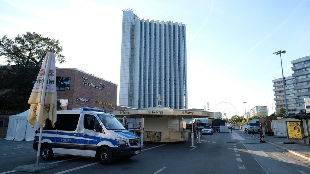 26.08.2018, Sachsen, Chemnitz: Ein Polizeifahrzeug steht in der Chemnitzer Innenstadt vor der Kulisse des Stadtfestes. Nach dem verhängnisvollen Streit in der Chemnitzer Innenstadt in der Nacht zu Sonntag mit einem Todesopfer und zwei Verletzten ende