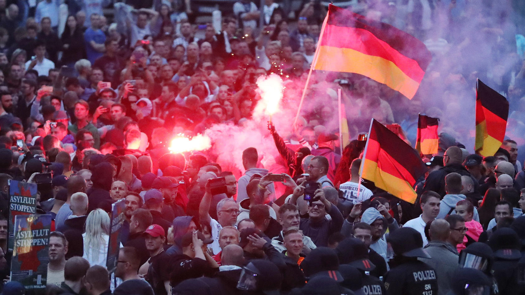 Chemnitz: Demonstranten der rechten Szene zünden Bengalos.