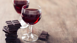 Zwei Gläser Rotwein mit Zartbitterschokolade.