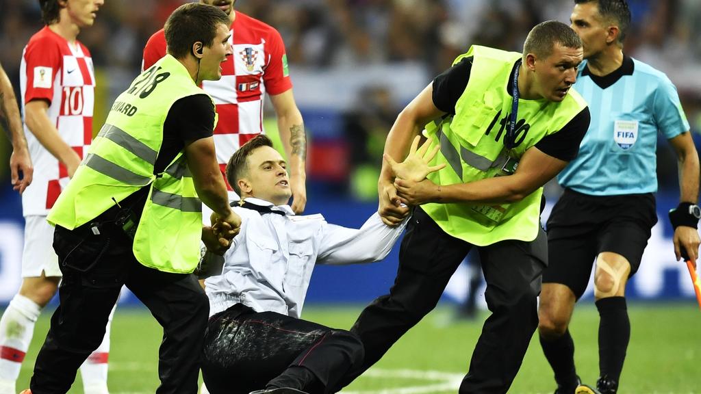 ARCHIV - 15.07.2018, Russland, Moskau: 15.07.2018, Russland, Moskau: Fußball: WM, Frankreich - Kroatien, Finalrunde Finale im Luschnikistadion. Sicherheitskräfte versuchen einen Flitzer zu stoppen und vom Spielfeld zu ziehen. Es handelt sich um dass