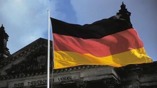 Eine wehende Deutschlandflagge vor einem Gebäude.