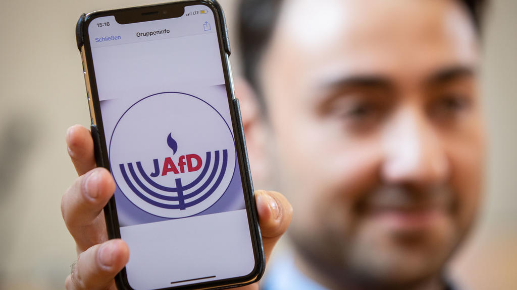 07.10.2018, Hessen, Wiesbaden: Beisitzer Leon Hakobian zeigt im Bürgerhaus im Stadtteil Erbenheim auf seinem Handy den vorläufigen Entwurf eines Logos der jüdischen Bundesvereinigung innerhalb der AfD, die wenig später gegründet werden sollte. Foto: