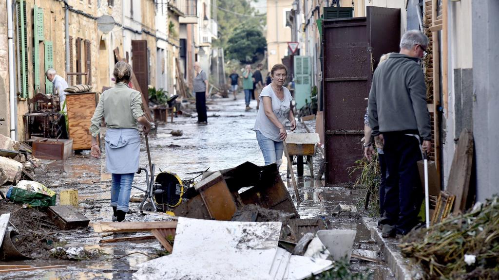 Several residents collaborate in the cleaning works of the streets in the village of Sant Llorenc des Cardasar, in Mallorca island, eastern Spain, 10 October 2018, a day after the flash floods hitting the area. At least ten people died and 5 years-ol