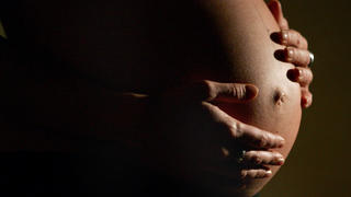 ARCHIV - 05.01.2007, Nordrhein-Westfalen, Bonn: Eine hochschwangere Frau fasst sich mit beiden Händen an ihren Bauch. (zu dpa "Frauen in Industrieländern bringen Kinder immer später zur Welt" vom 17.10.2018) Foto: Felix Heyder/dpa +++ dpa-Bildfunk +++
