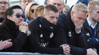 Khun Aiyawatt Srivaddhanaprabha, son of Leicester City's owner Thai businessman Vichai Srivaddhanaprabha, Jamie Vardy and Kasper Schmeichel look at tributes left for Vichai and four other people who died when the helicopter they were travelling in crashed as it left the ground after the match on Saturday, in Leicester, Britain, October 29, 2018. REUTERS/Peter Nicholls