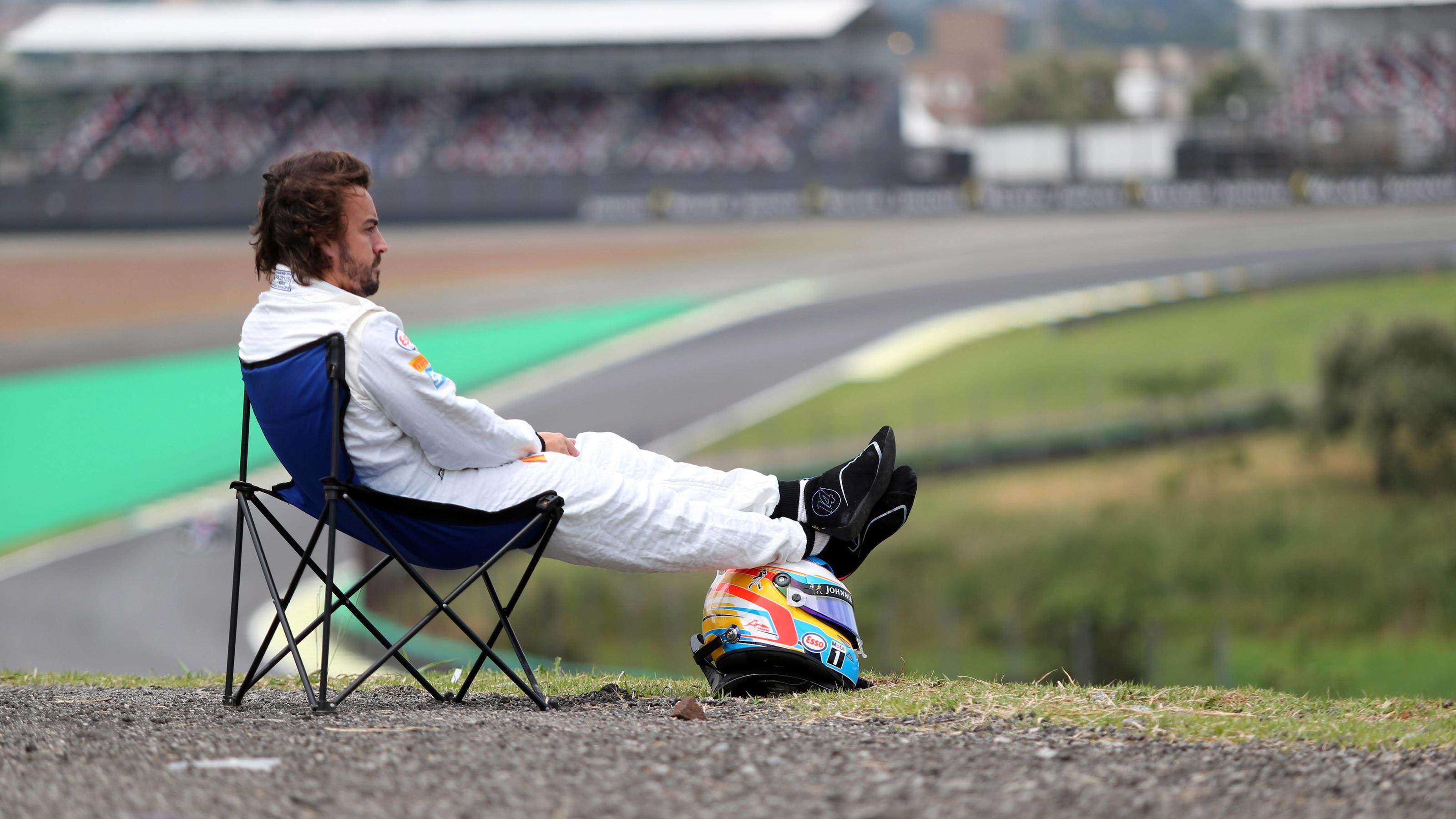 Das Bild ging 2015 um die Welt: Weil sein McLaren wieder einmal streikte, nimmt Fernando Alonso im Qualifying von Sao Paulo ein Sonnenbad