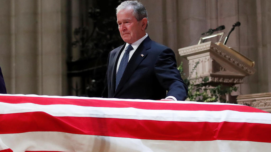 Former President George W. Bush touches the casket of his father, former President George H.W. Bush, at the State Funeral at the National Cathedral, Wednesday, Dec. 5, 2018, in Washington. Alex Brandon/Pool via REUTERS