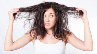 Frau mit fettigen, zerstrubbelten Haaren