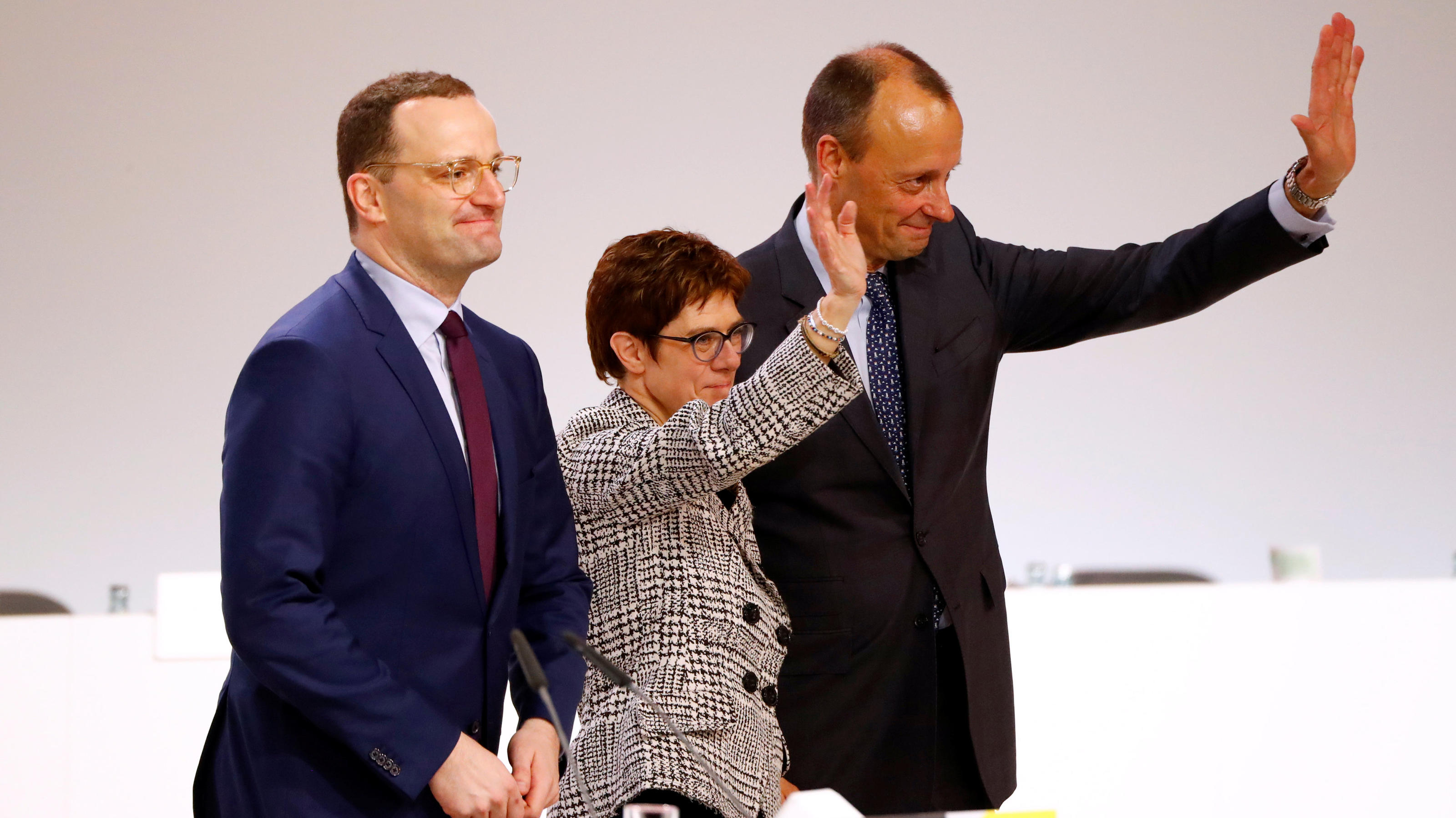 Annegret Kramp-Karrenbauer waves with fellow candidates Jens Spahn and Friedrich Merz after being elected as the party leader during the Christian Democratic Union (CDU) party congress in Hamburg, Germany, December 7, 2018. REUTERS/Fabrizio Bensch
