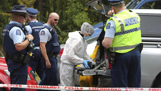 09.12.2018, Neuseeland, Auckland: Polizisten stehen hinter einer Absperrung entlang eines Abschnitts des «Scenic Drive» in der Waitakere Bergkette. Die neuseeländische Polizei glaubt, dass die seit einer Woche vermisste 22-jährige britische Touristin ermordet wurde. Die Polizeit will Anklage gegen einen Mann erheben, den sie früher am Tag zur Befragung festhielten. Foto: Doug Sherring/New Zealand Herald/AP/dpa +++ dpa-Bildfunk +++