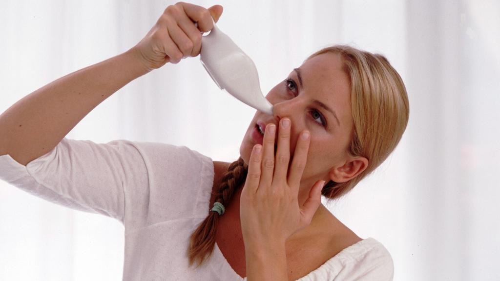 Eine Frau verwendet eine Nasendusche. 