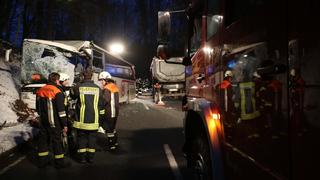 18.12.2018, Bayern, Fürstenstein: Feuerwehrleute stehen nach einem vor einem beschädigten Bus. Bei einem Unfall mit dem Schulbus und einem Lastwagen ist der Fahrer des Sattelschleppers ums Leben gekommen. (zu dpa «Mehrere Kinder bei Schulbus-Unfall verletzt - Lastwagenfahrer tot» vom 18.12.2018) Foto: Kölbl/zema-foto.de/dpa +++ dpa-Bildfunk +++