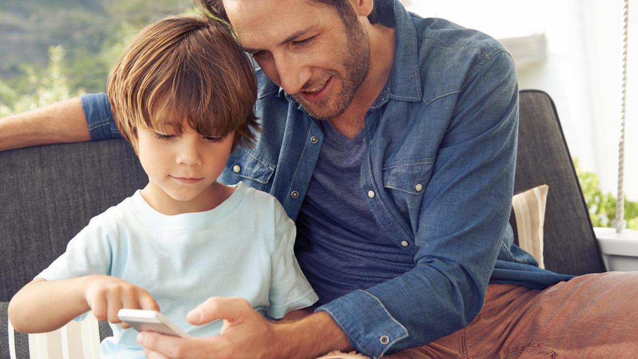 Ein Vater erklärt seinem Sohn das Smartphone.