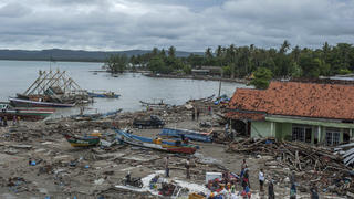 24.12.2018, Indonesien, Sumur: Menschen untersuchen die Schäden in einem von einem Tsunami getroffenen und verwüsteten Dorf. Nach der Tsunami-Katastrophe in Indonesien haben Rettungsteams in den betroffenen Küstengebieten auf den Inseln Java und Sumatra die Suche nach Überlebenden und Opfern fortgesetzt. Die Zahl der Toten stieg bis Montag den 24.11.2018 auf mindestens 281, wie der indonesische Katastrophenschutz mitteilte. Foto: Fauzy Chaniago/AP/dpa +++ dpa-Bildfunk +++