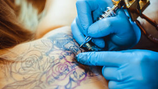 Tätowierer sticht Tattoo