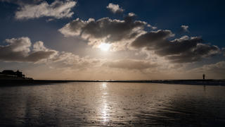 09.01.2019, Niedersachsen, Borkum: Die Sonne leuchtet hinter Wolken am Strand von Borkum hervor. Foto: Mohssen Assanimoghaddam/dpa +++ dpa-Bildfunk +++