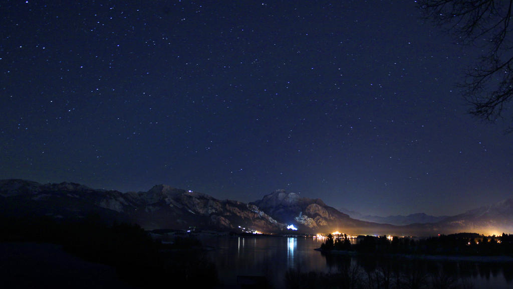 Unter einem wolkenlosen Sternenhimmel spiegeln sich am Montag (16.01.2012) die Lichter des Schlosses Neuschwanstein und der Stadt Füssen (Schwaben) im Forggensee. Sonne am Tag und kalte klare Nächte bestimmen das Wetter im südwestlichen Bayern. Foto: