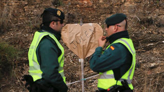 Spanish Civil Guards stand on a road next to a banner in the shape of heart at the area where Julen, a Spanish two-year-old boy, fell into a deep well seven days ago when the family was taking a stroll through a private estate, in Totalan, southern Spain, January 20, 2019. REUTERS/Jon Nazca