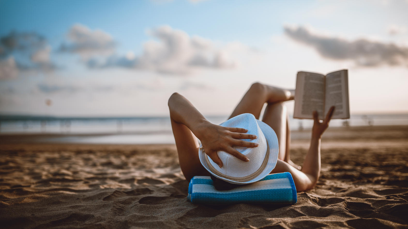 Frau liest am Strand