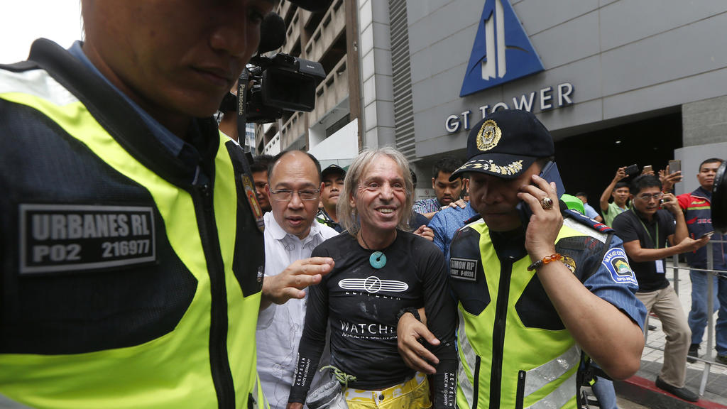29.01.2019, Philippinen, Makati: Der als «Spiderman» bekanntgewordene Fassadenkletterer Alain Robert(M) wird von der Polizei festgenommen, nachdem er das 47-stöckige GT Tower Building im Finanzdistrikt von Makati City östlich von Manila bestiegen hat