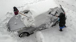 03.02.2019, Österreich, Salzburg: Anwohner befreien ein Auto vom Schnee. Erneut gab es in der Nacht starke Schneefälle in Salzburg. Foto: Franz Neumayr/APA/dpa +++ dpa-Bildfunk +++