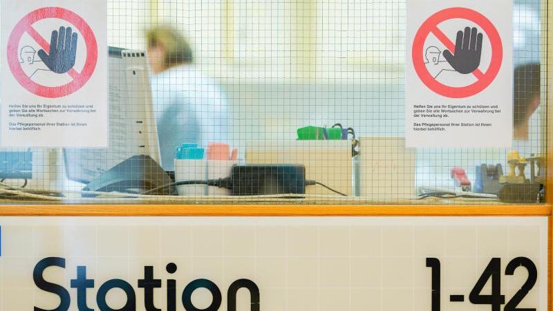 Ein Warnschild gegen mögliche Diebstähle an der Glasscheibe eines Stationszimmers in einem Klinikum. Foto: Uwe Anspach