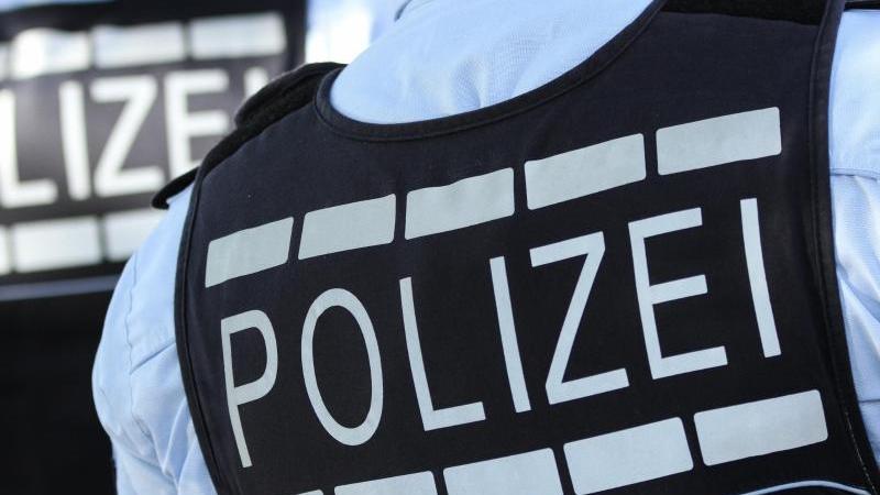 Ein Polizist trägt eine Weste mit der Aufschrift «Polizei»