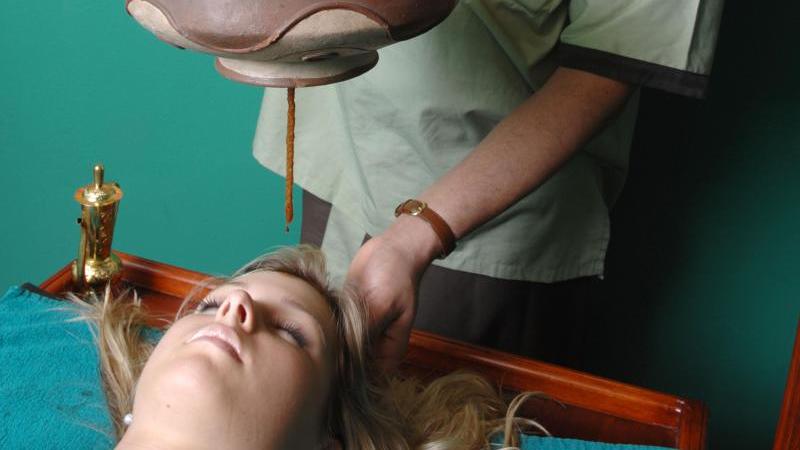 Eine Frau erhält eine traditionelle Ayurveda-Anwendung.