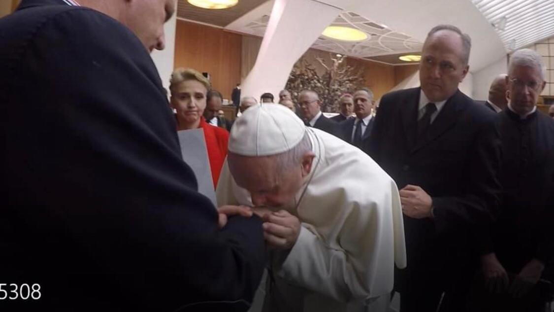 Papst Franziskus küsst Missbrauchsopfer die Hand.