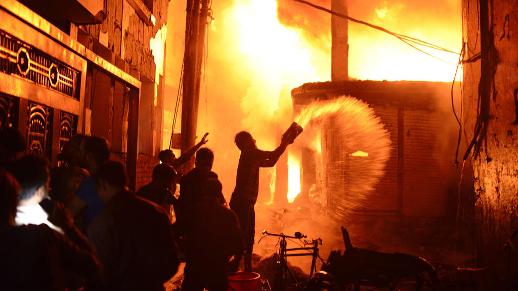 21.02.2019, Bangladesch, Dhaka: Feuerwehr und Anwohner versuchen einen Brand zu löschen. Bei einem Großbrand in Bangladeschs Hauptstadt Dhaka sind dutzende Menschen ums Leben gekommen. Das sagte der diensthabende Offizier der Feuerwehr und des Zivils