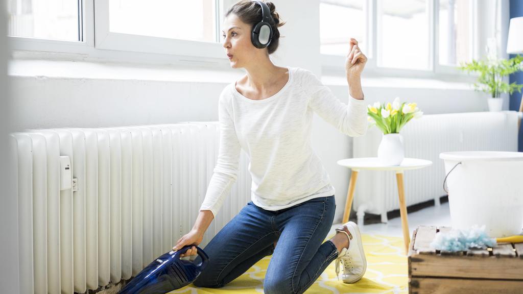 Woman at home wearing headphones hoovering the floor model released Symbolfoto property released PUBLICATIONxINxGERxSUIxAUTxHUNxONLY MOEF00800