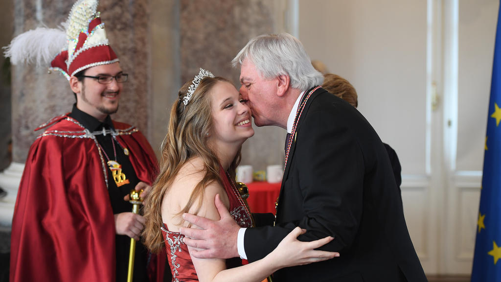 09.02.2019, Hessen, Wiesbaden: Patricia I., Karnevalsverein Alsbach, bekommt von Volker Bouffier (CDU), Ministerpräsident von Hessen, einen Kuss auf die Wange. Michael I., Karnevalsverein Alsbach, schaut den Beiden zu. Der hessische Ministerpräsident