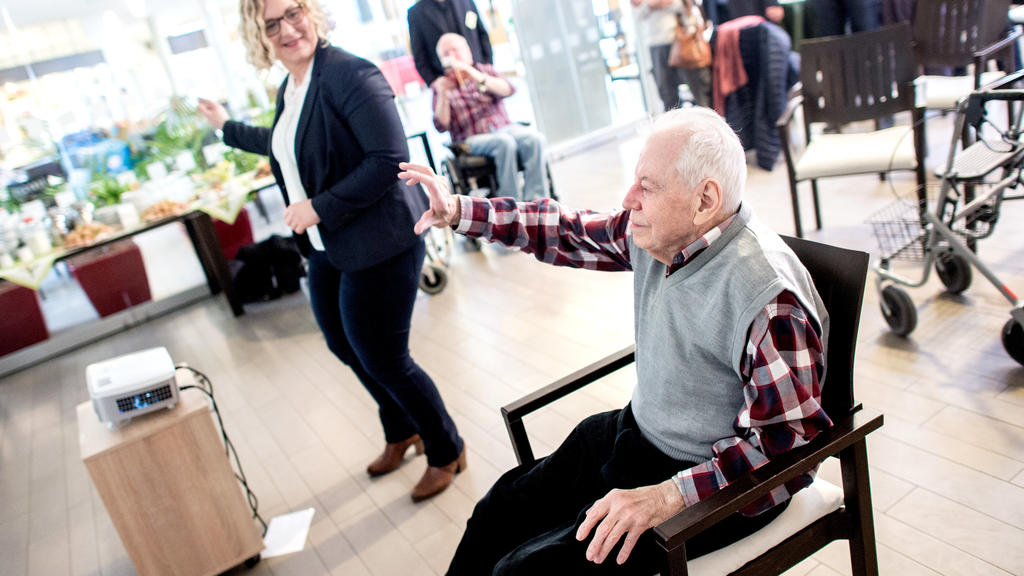07.03.2019, Niedersachsen, Hannover: Bernhard Pischel (r), Bewohner im Alten- und Pflegeheim Heinemanhof, und Sandra Mehmecke, Präsidentin der Pflegekammer Niedersachsen, tanzen in einem Videospiel auf speziell für Ältere entwickelten Spielekonsole "