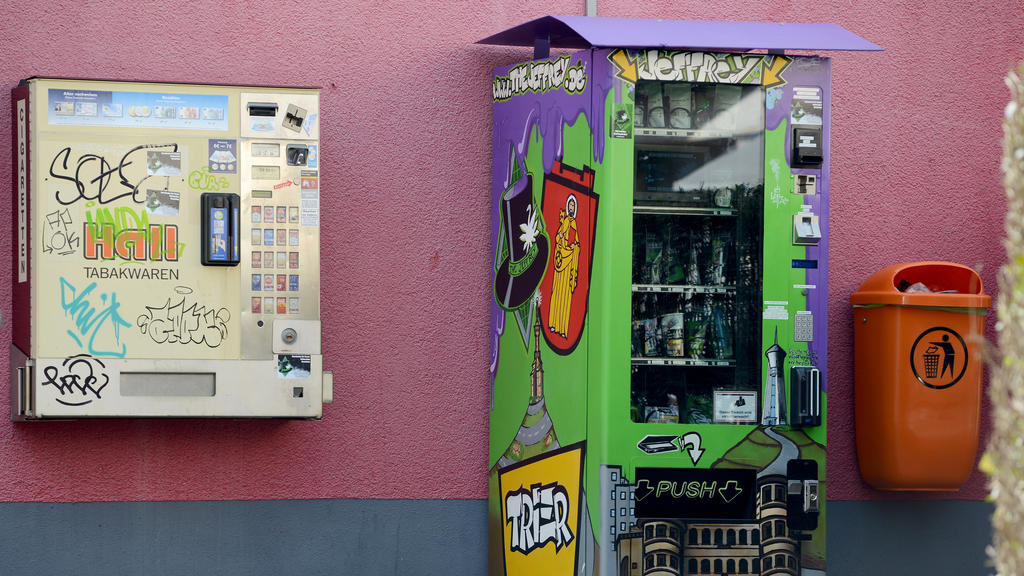 21.03.2019, Rheinland-Pfalz, Trier: Ein Cannabis-Automat (r), der gepresste und getrocknete Cannabis-Blüten in Tütchen sowie Extrakt-Kügelchen in Plastikdöschen plus allerlei Rauchzubehör zum Kauf enthält, steht auf der Straße neben einem Tabakautoma
