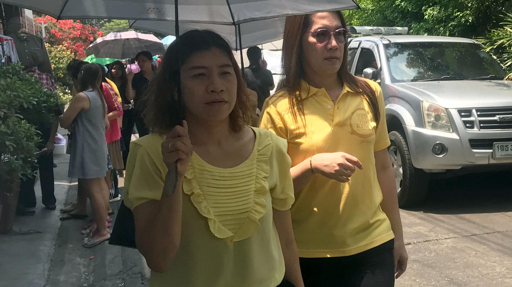 01.04.2019, Thailand, Bangkok: Passanten sind in gelber Kleidung auf einer Straße in der Hauptstadt unterwegs.  Zu Ehren ihres bislang noch ungekrönten Königs M. Vajiralongkorn sollen die knapp 70 Millionen Thailänder bis Ende Juli gelbe Kleidung tra
