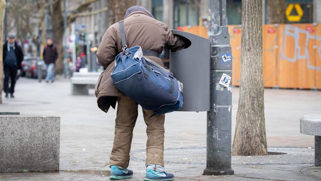 ARCHIV - 27.03.2019, Berlin: Ein Flaschensammler greift am Kudamm in eine Mülltonne. Die Bertelsmann Stiftung veröffentlicht am 02.04.2019 eine Umfrage zur Wahrnehmung von Armut in deutschen Kommunen. Foto: Kay Nietfeld/dpa +++ dpa-Bildfunk +++