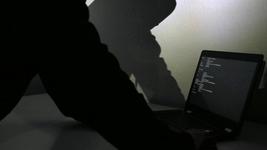 ARCHIV - 17.01.2018, Bayern, München: ILLUSTRATION - zum Thema Darknet. Hinter einem Laptop-Bildschirm wird der Schatten eines Mannes an die Wand geworfen. Foto: Lisa Forster/dpa +++ dpa-Bildfunk +++
