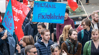 ARCHIV - 20.10.2018, Hessen, Frankfurt/Main: Mit einem Plakat mit der Aufschrift «Miethaie zu Fischstäbchen» zieht eine Demonstrantin durch die Frankfurter Innenstadt. (zu «Demos und Volksbegehren - Menschen stehen gegen «Mietenwahnsinn» auf ») Foto: Frank Rumpenhorst/dpa +++ dpa-Bildfunk +++