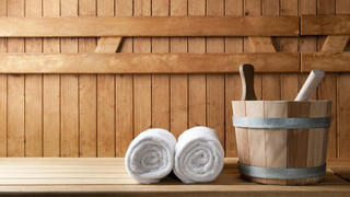 Detail of bucket and white towels in a sauna.