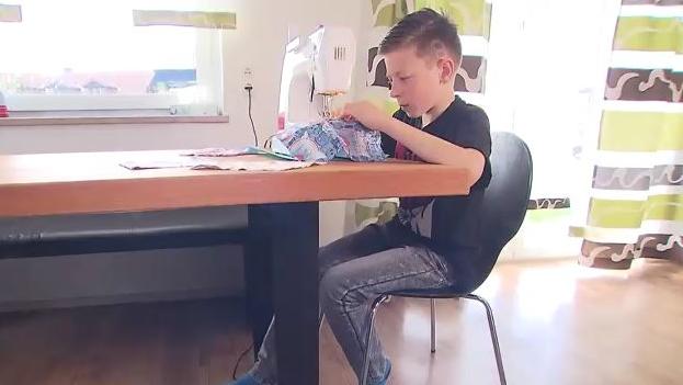 Nico sitzt an der Nähmaschine