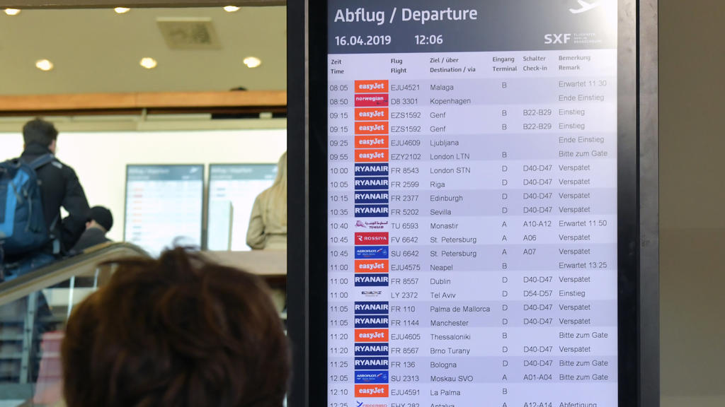 Berlin-Schönefeld: Eine Reisende checkt im Flughafen die Anzeige für die Abflüge.